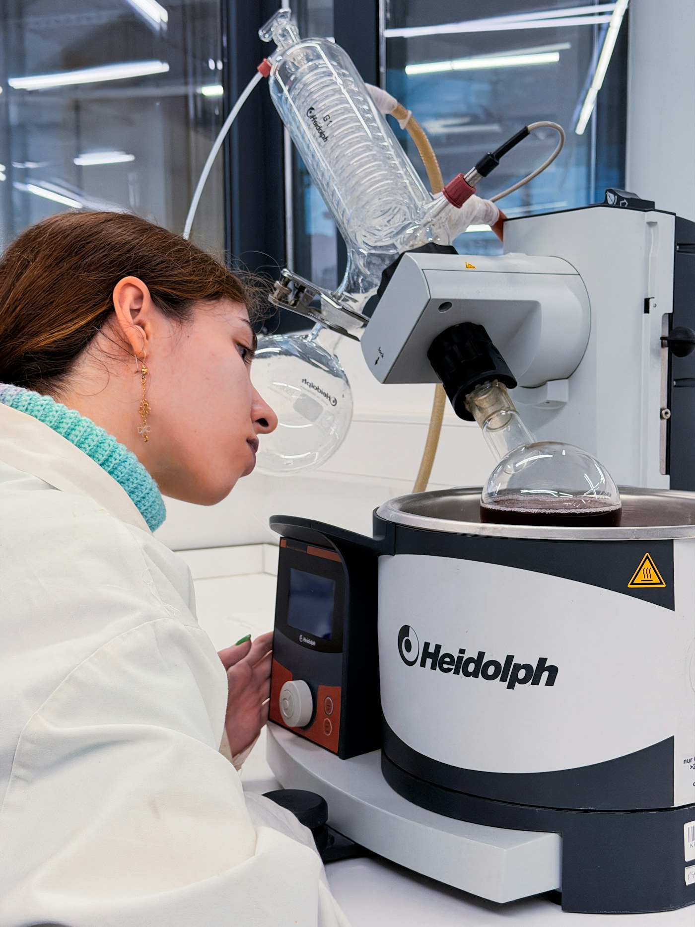 Researcher performing custom chemical synthesis with laboratory instrumentation